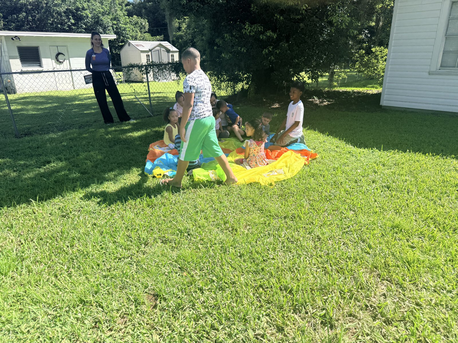 Children and teachers enjoying a colorful parachute activity outdoors