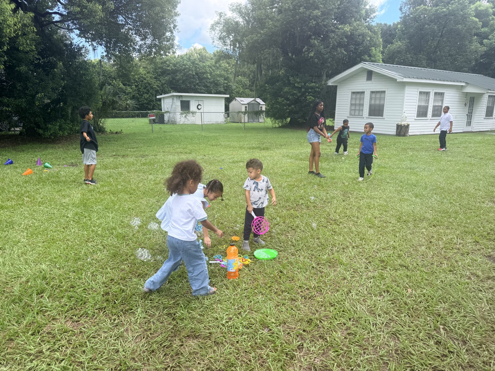 Children enjoying outdoor play with bubbles and activity equipment
