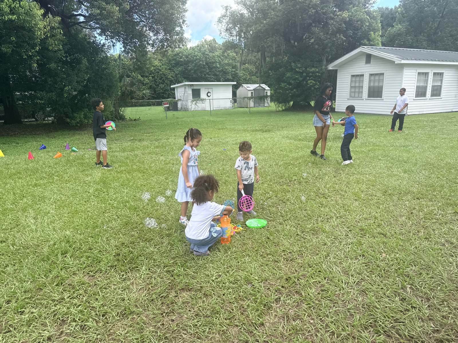 Children playing outside with jump ropes, balls, and activity equipment