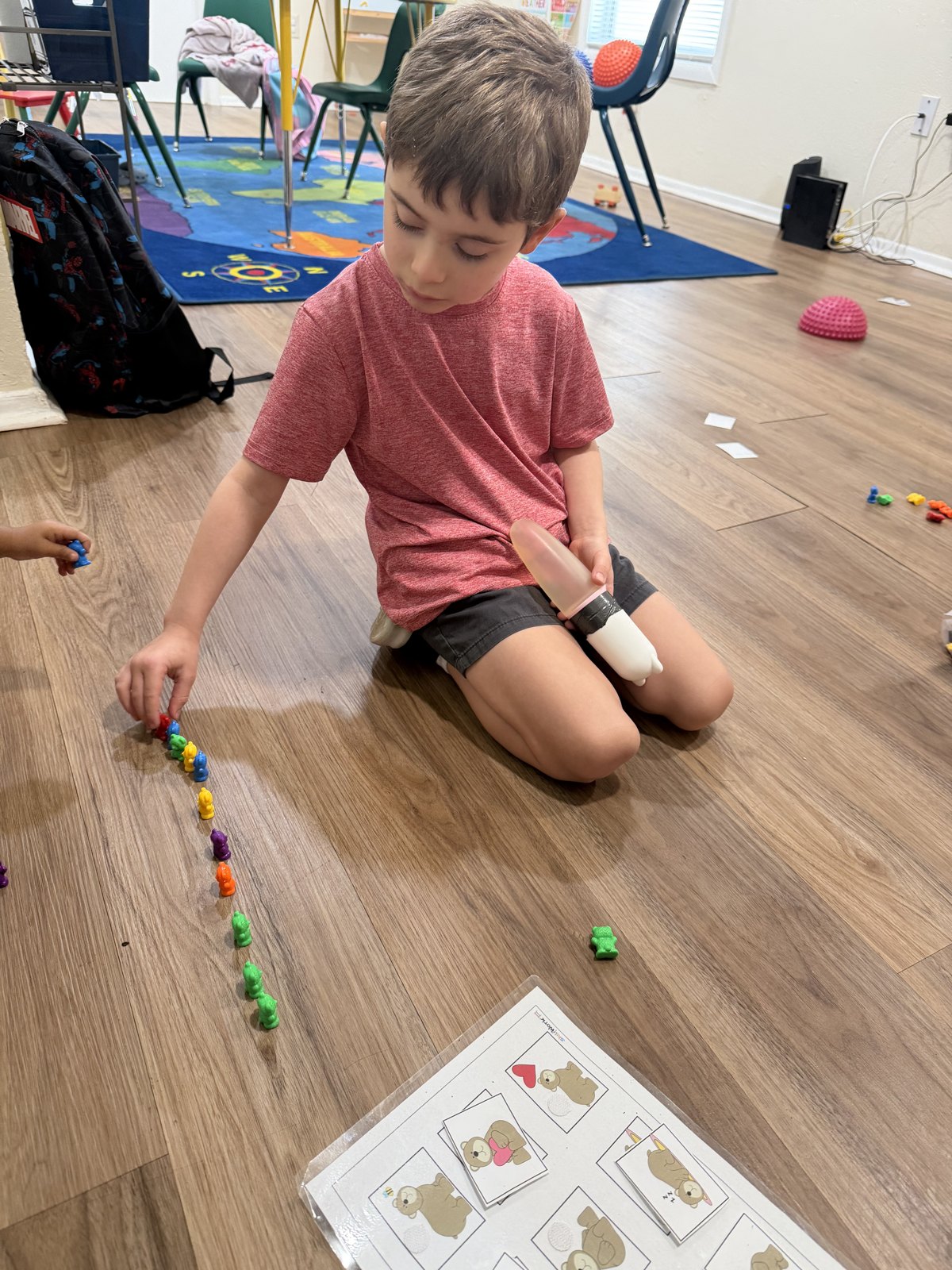 Young learner arranging colorful bear counters during a classroom activity