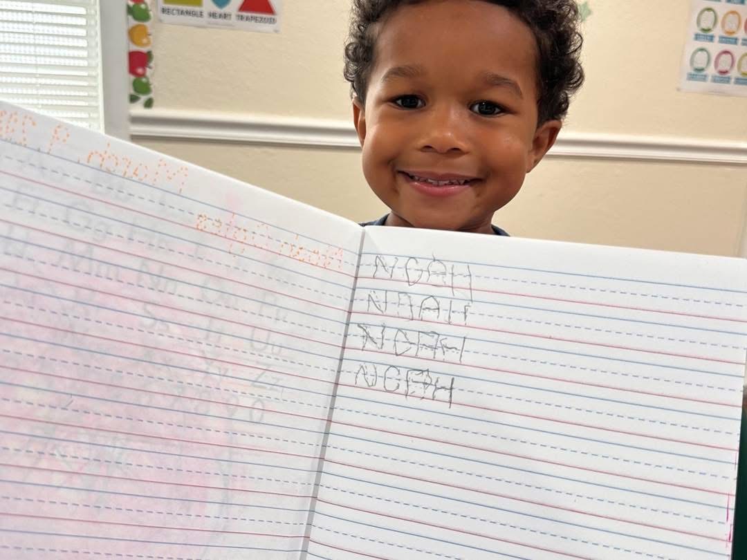 Young student proudly showing schoolwork